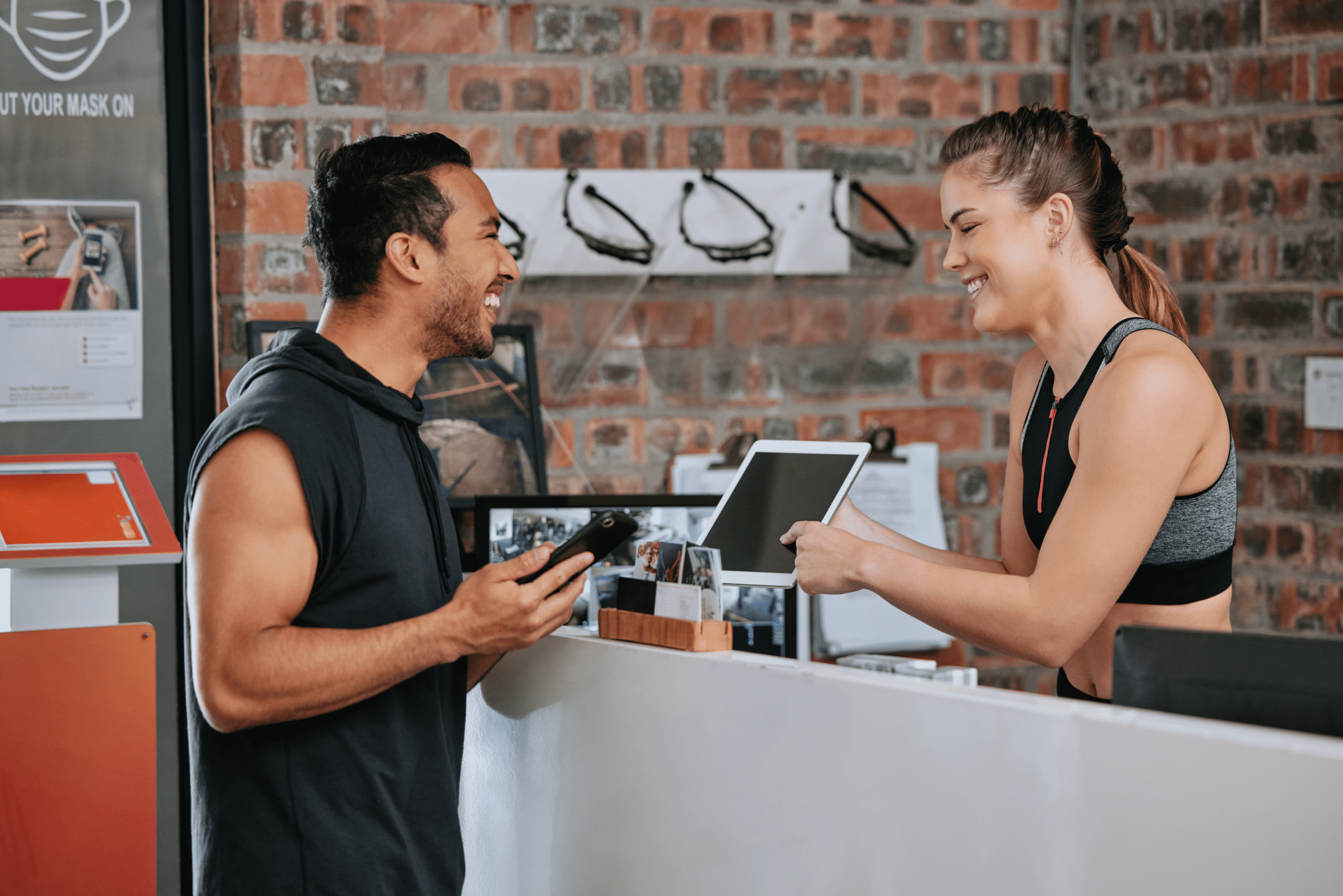 Clubwise | Man signing up for gym membership on ipad at front desk