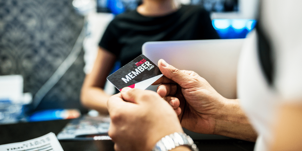 gym member at front desk with membership card