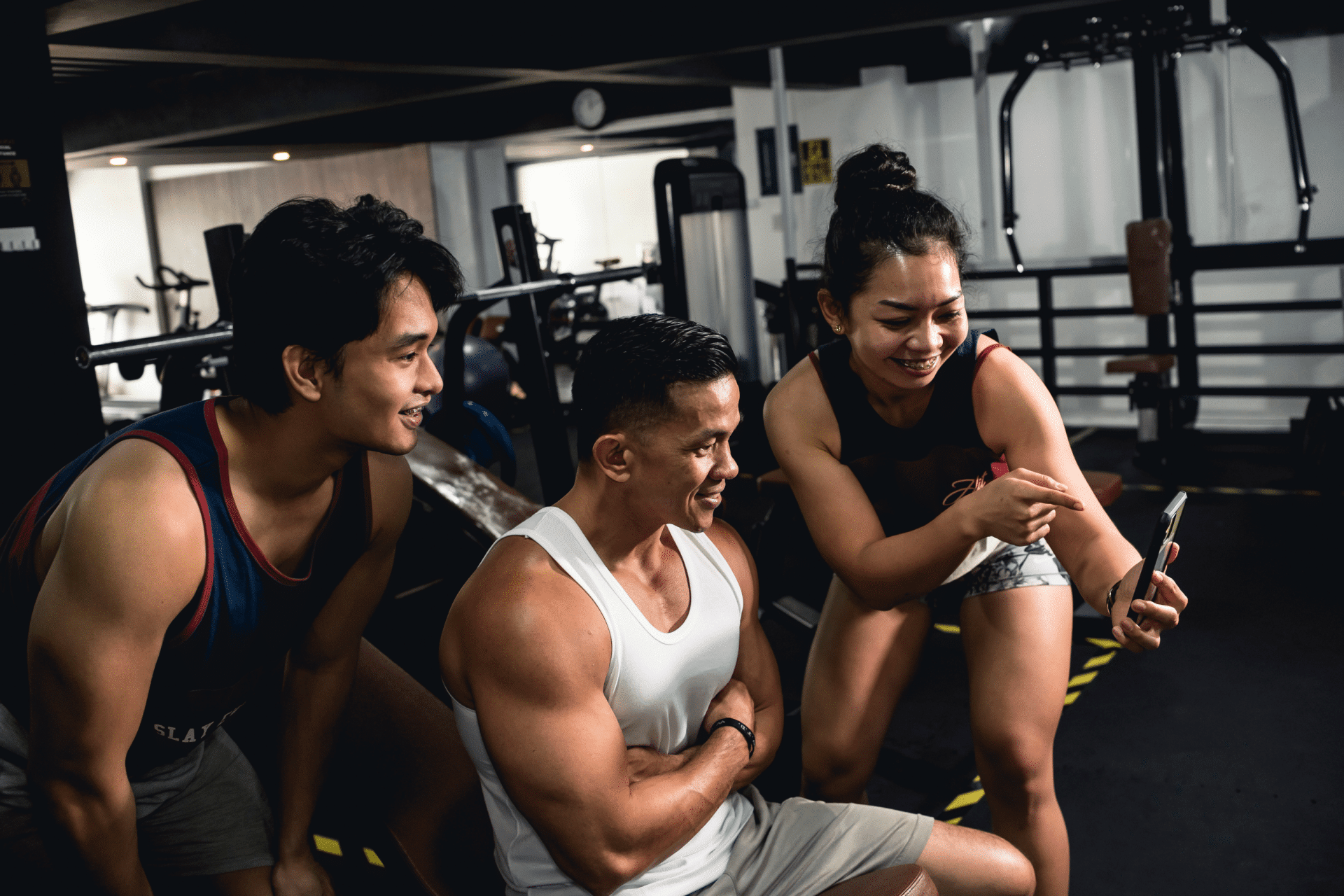 Clubwise | three people in gym looking at phone